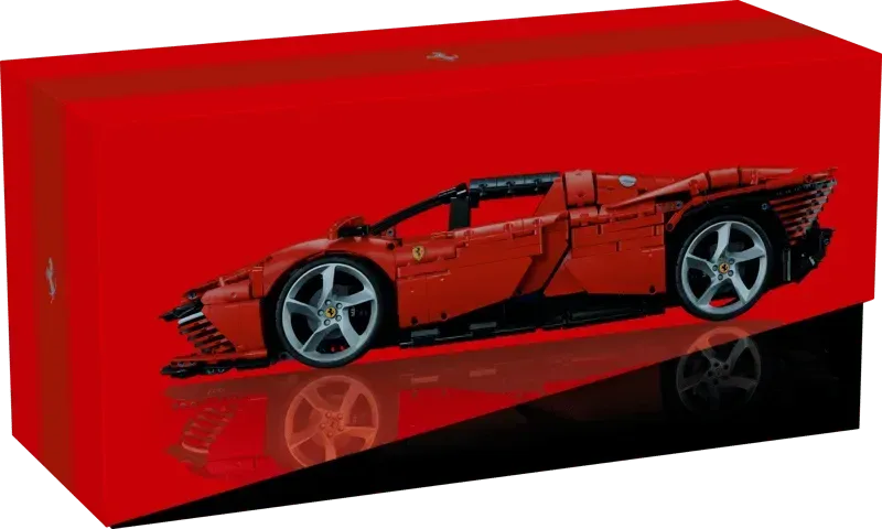 A vibrant red product box featuring the Lego Ferrari Daytona SP3, with a glossy reflection on a black surface, highlighting its premium presentation.