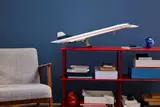 Lego Concorde displayed on red shelf.