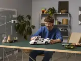 Man interacting with Lego Countach model.
