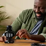 Man interacting with Darth Vader Bust.
