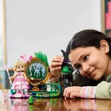 Girl playing with Lego Elphaba & Glinda figures.