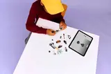 Child building LEGO with tablet instructions.