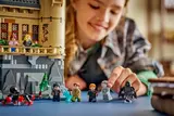 Child playing with Lego Hospital Wing and minifigs.