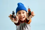 Child showcasing LEGO Ninjago bikes.
