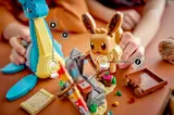 Hands playing with Eevee and Lapras.