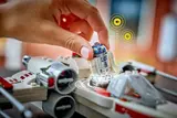 Hand placing R2-D2 in X-Wing, showing SMART Play interaction.
