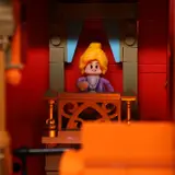 Minifigure on illuminated theatre balcony.