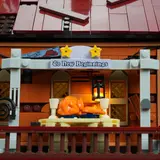 Balcony feast scene with illuminated sign and turkey.