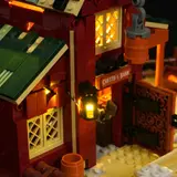 Close-up of glowing lantern and barn door at night.